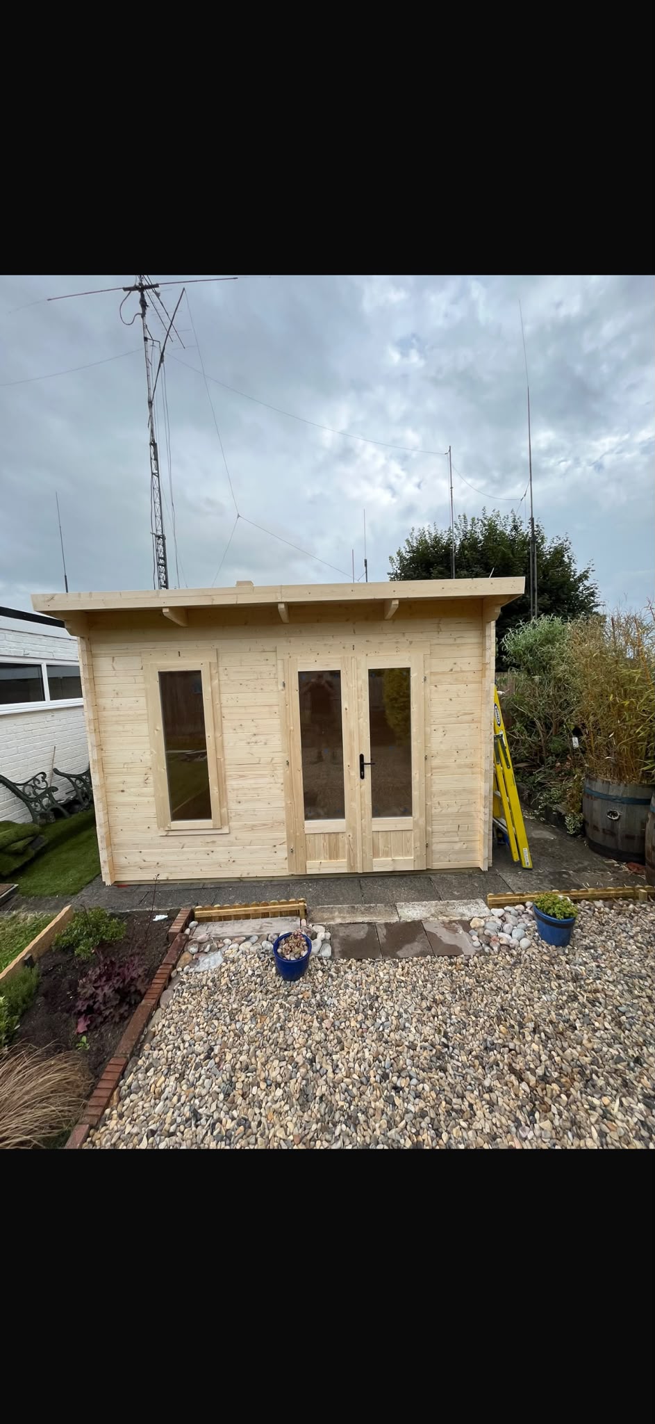 A timber garden building with glazed double doors.